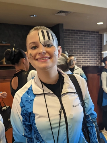 Smiling girl with piano key face paint in a white to blue hombre jacket
